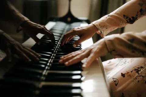 Mekhriban Mamedova's hands moving across the piano keyboard in warm daylight.